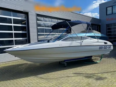witte sportboot op trailer bij showroom