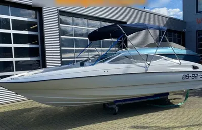 witte sportboot op trailer bij showroom