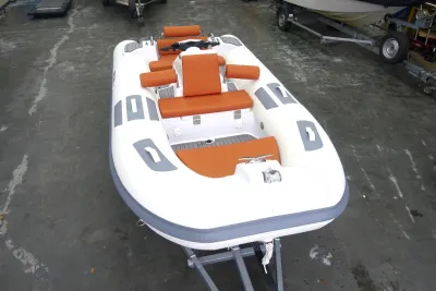 witte opblaasboot met oranje kussens