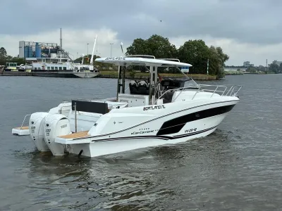 witte sportboot op water bij kade