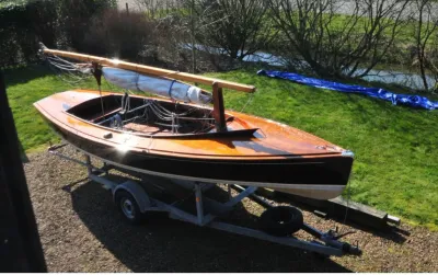 houten zeilboot op trailer op grasveld