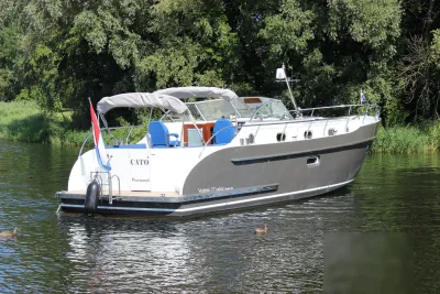 motorjacht op rustig water langs beboste oever