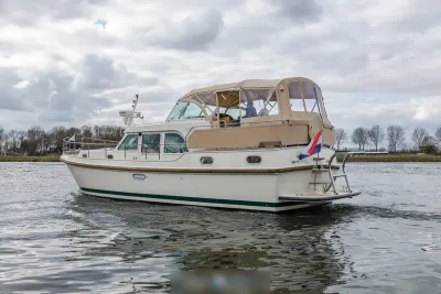 wit motorjacht met beige kuipkap op water