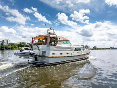 Motorjacht op rivier onder bewolkte lucht