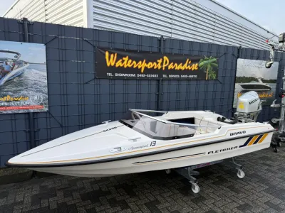 kleine open speedboot op trailer bij hek