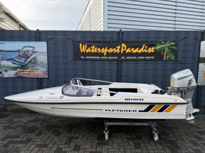 kleine open boot op trailer bij hek