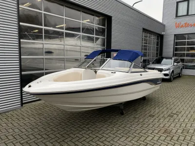 witte bowrider met blauwe bimini op trailer
