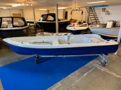 kleine blauwe en witte sloep in showroom