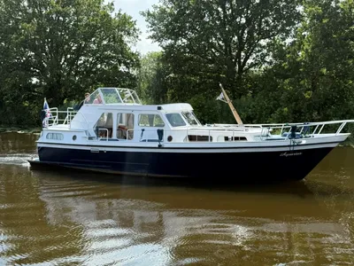 motorjacht op kanaal met bomen op achtergrond