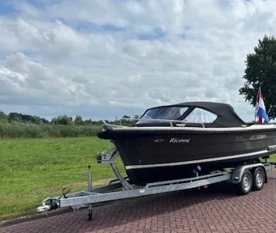 sloep op trailer bij weg en grasveld