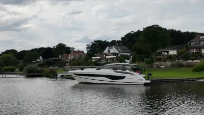 motorjacht aangemeerd bij woonoever