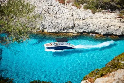 motorboot in helder blauw water bij rotsen