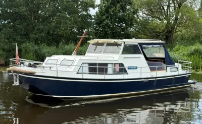 witte en blauwe motorboot op stil water bij riet