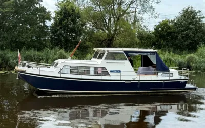 motorjacht op rivier met rietkade