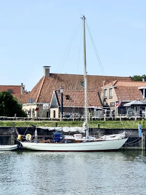 zeiljacht aangemeerd in haven met huizen