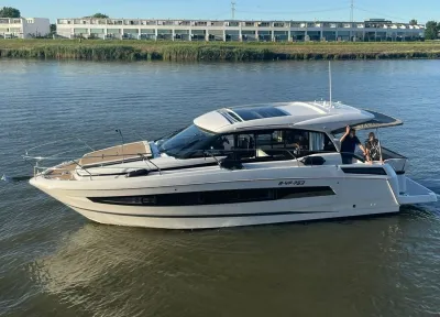 motorjacht op rivier met personen op achterdek