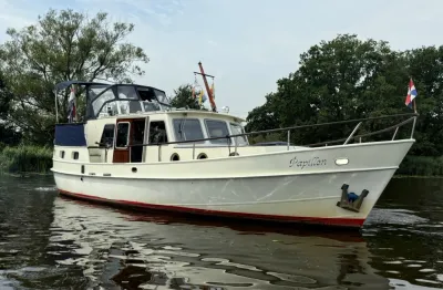 wit motorjacht op water met bomen op achtergrond