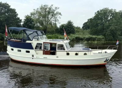 wit motorjacht op rustig water langs oever