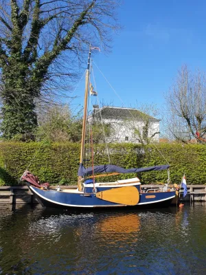 kleine houten zeilboot bij kade