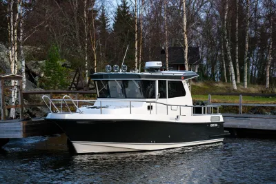 Pilothousejacht afgemeerd bij houten steiger