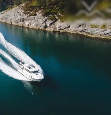 wit motorjacht vaart tussen rotsachtige oevers