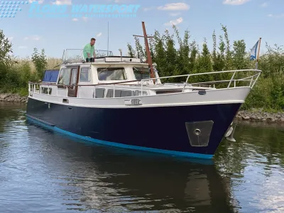 motorjacht afgemeerd bij groene oever