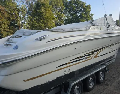 witte sportboot op trailer bij bomen