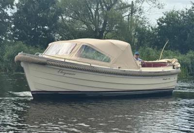 sloep met beige kap op stil water