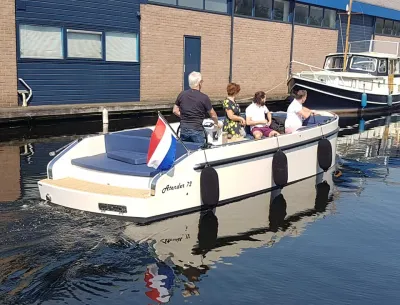 witte sloep met vier mensen in kanaal