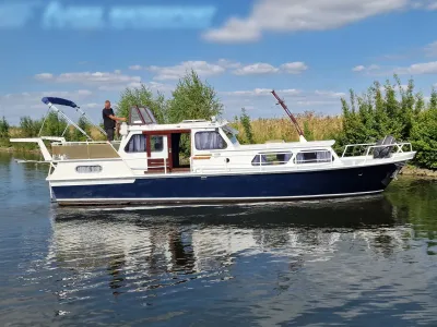 motorjacht op kanaal met bomen op achtergrond