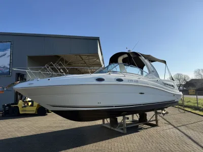 Witte motorboot op bokken bij werf
