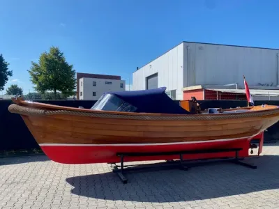 houten sloep op bok bij industrieel terrein