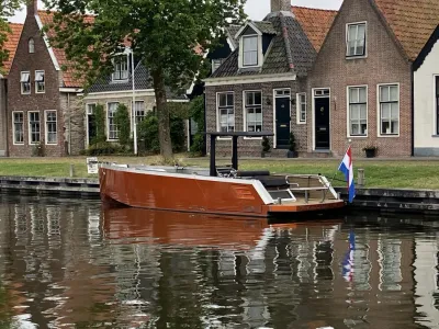 bruine tenderboot aangemeerd in kanaal