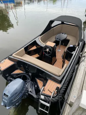 sloep afgemeerd naast een houten steiger