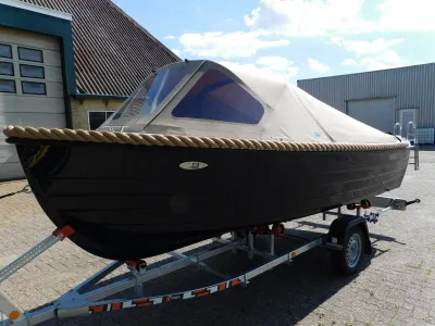 sloep op trailer bij bedrijfsgebouw