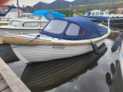 witte sloep met blauwe kuiptent in haven