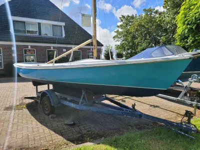 blauwe zeilboot op trailer op oprit