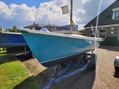 blauwe zeilboot op trailer buiten