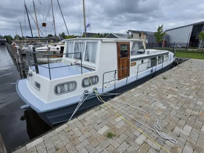 witte motorboot afgemeerd bij steiger
