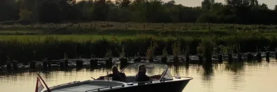 sloep op rustig water bij zonsondergang