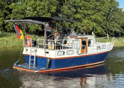 motorjacht op rustig water voor groene oever