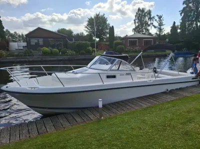 witte motorboot afgemeerd aan houten steiger