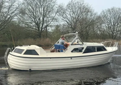 witte motorboot op rivier met bestuurder