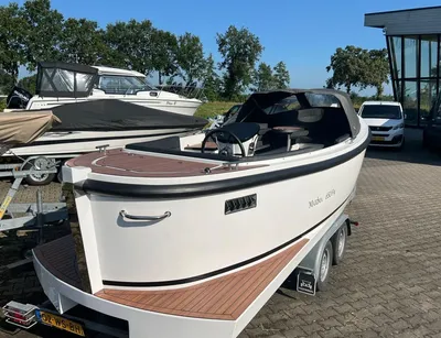 witte boot op trailer bij showroom