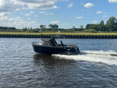 zwarte tender op kanaal met bewolkte lucht