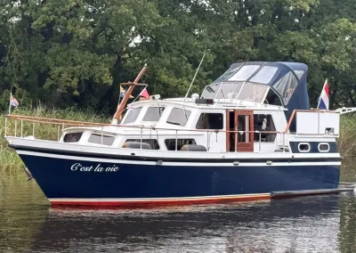 motorjacht op rustig water langs oever
