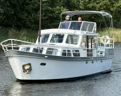 wit motorjacht op rustig water met twee personen