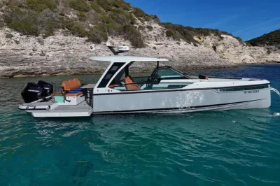 sportboot voor anker bij rotsachtige kust