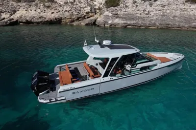 motorboot voor anker bij rotsachtige kust