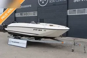 witte motorboot op trailer voor gebouw
